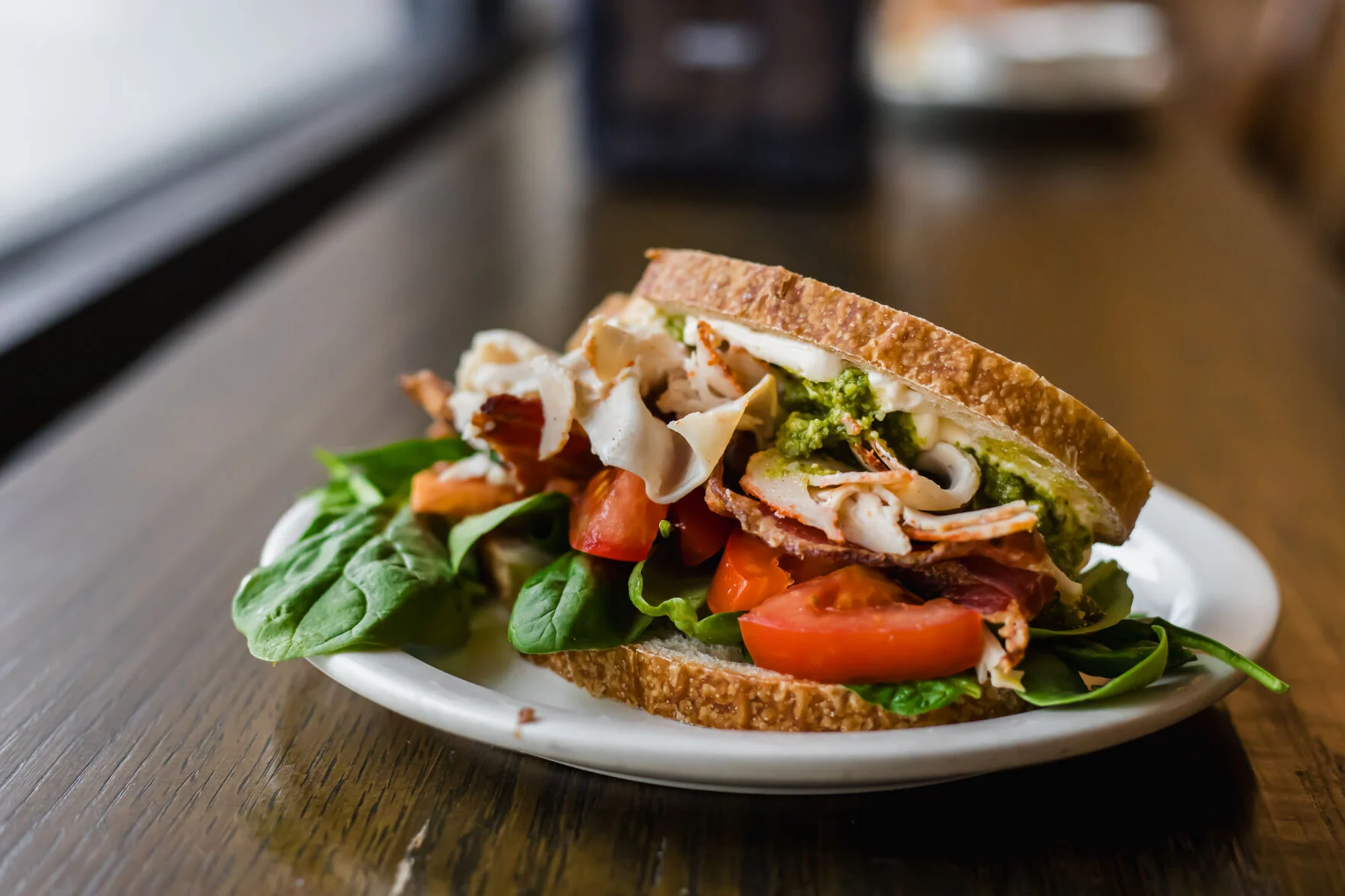 A turkey and pesto sandwich on a plate at 222 Artisan Bakery